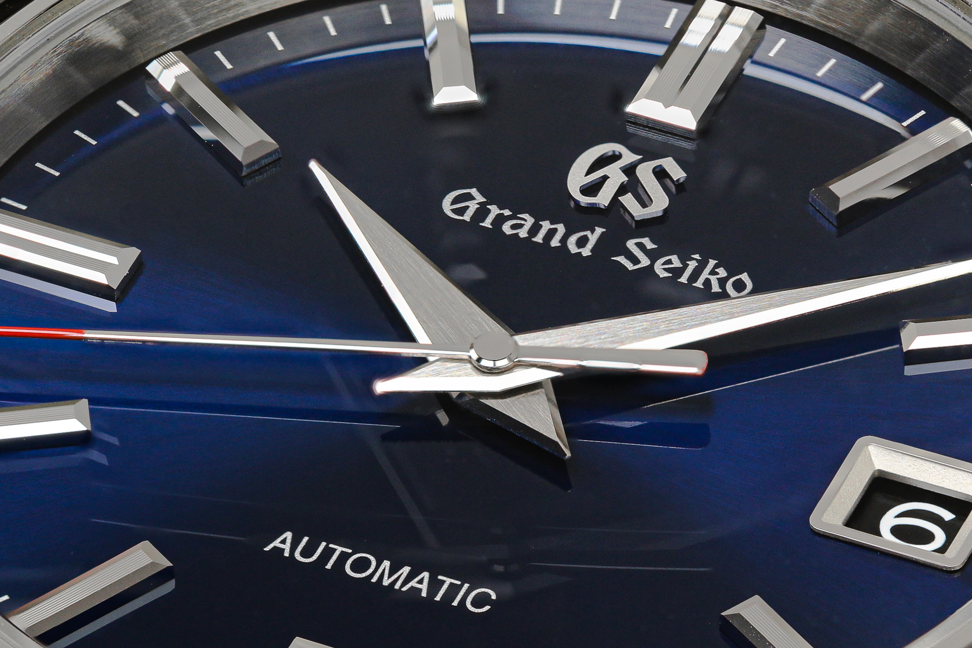 Macro of Grand Seiko SBGR321 wristwatch with a blue dial and red accents.