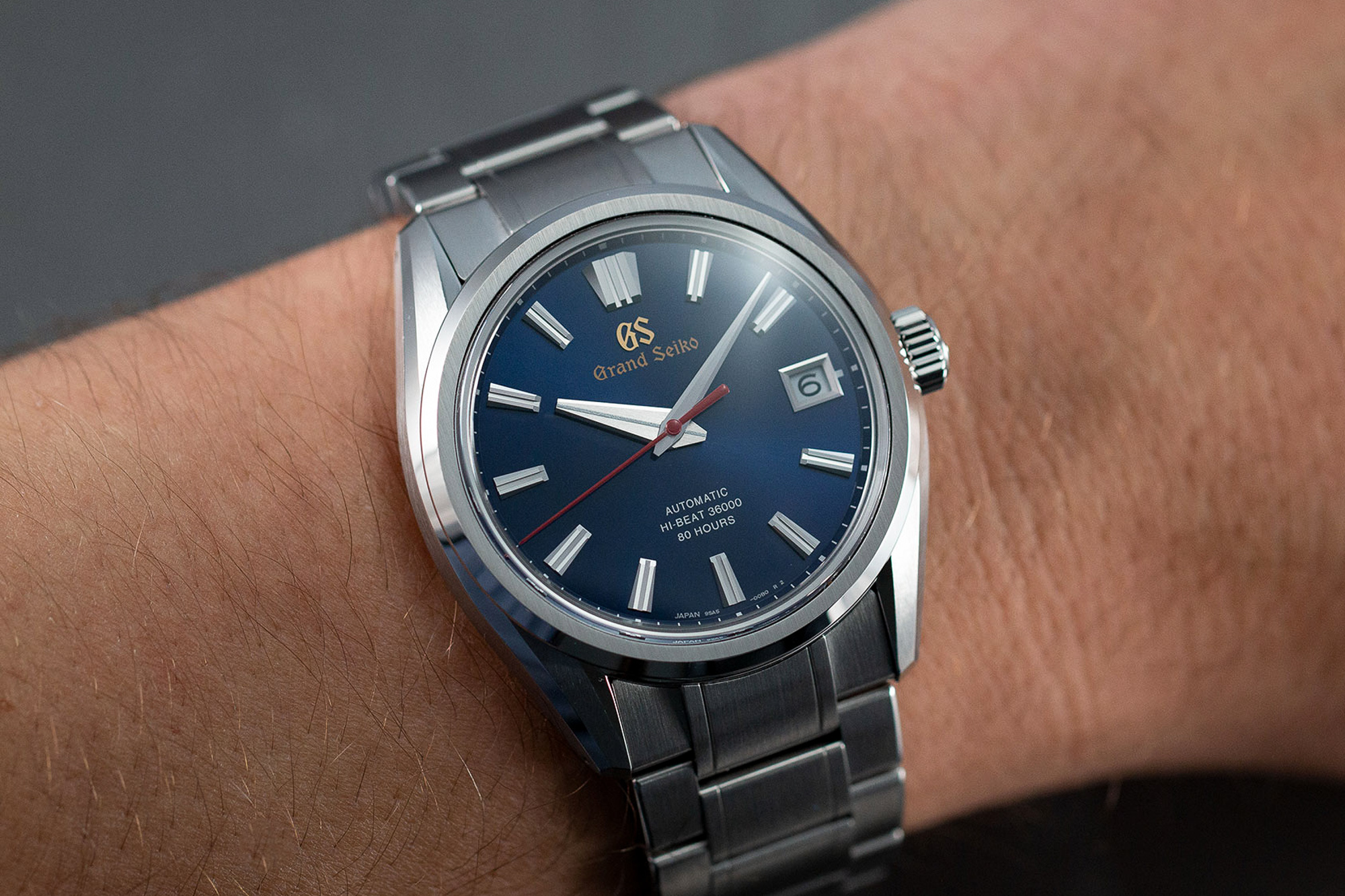 Grand Seiko SLGH003 blue dial stainless steel wristwatch on a wrist.