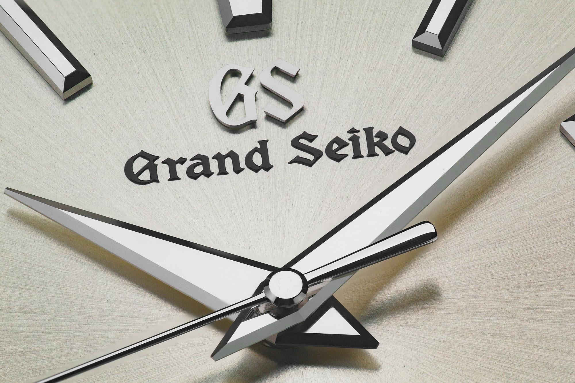 Macro detail of Grand Seiko SBGP009 showing hands, indexes, and logo.