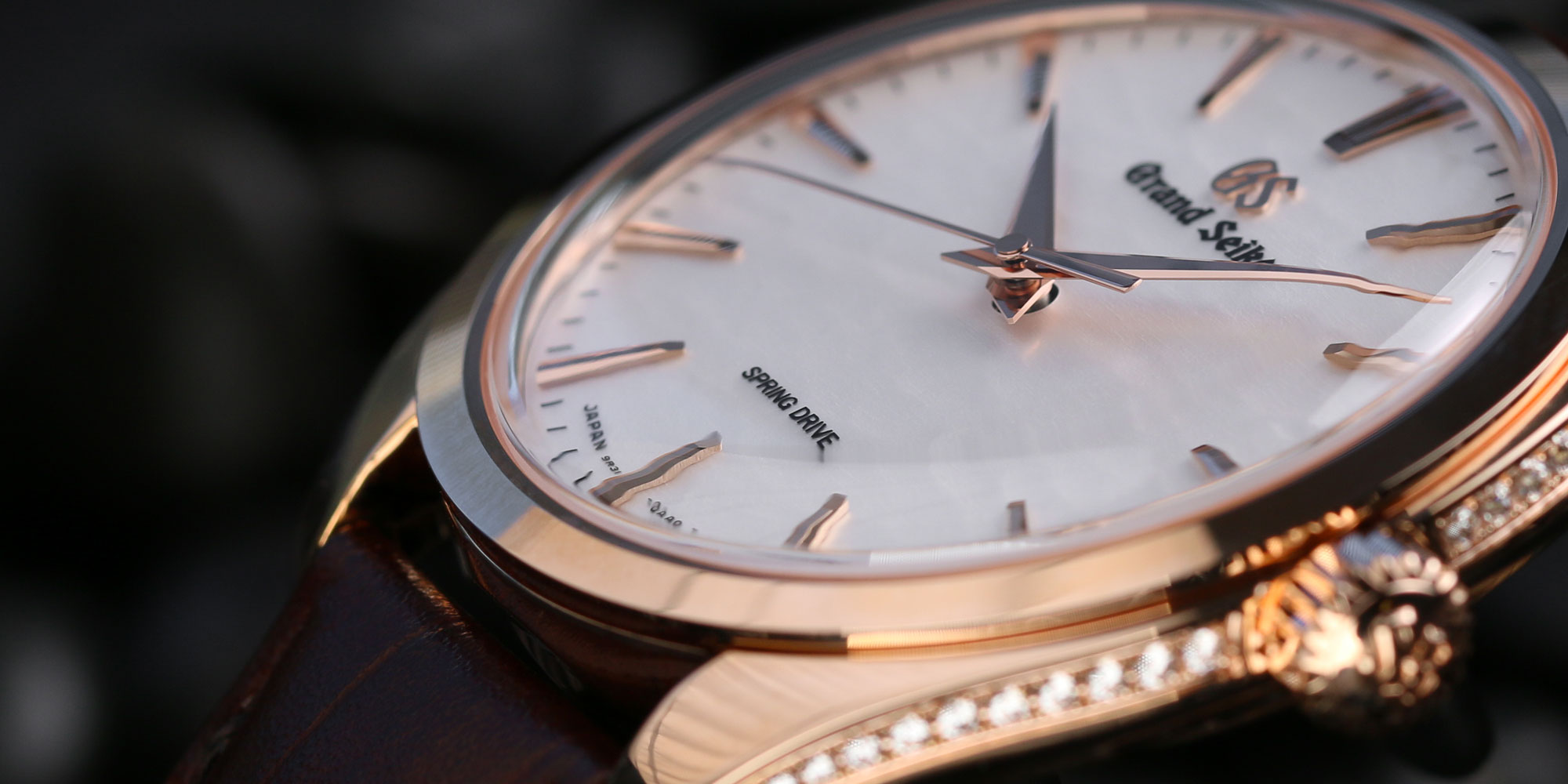Dial closeup (off angle) of Grand Seiko SBGY008 18k gold watch.