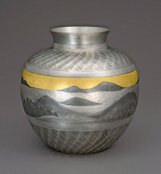 An ornamental metal vase with hammered details depicting a natural scene, done via tankin.